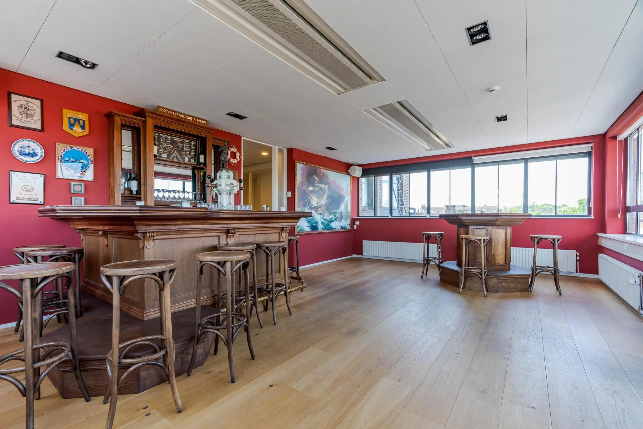 Sfeervolle ruimte met een klassieke houten bar en barkrukken aan de Van Alkemadelaan.